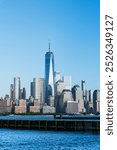 View of the Manhattan skyline from Hoboken, New Jersey, set against a clear blue sky.