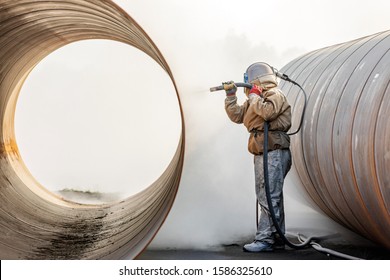 View of the manual sandblasting or abrasive blasting in the construction site. The difference between sandblasting and grit blasting, as shot blasting is often called, is straightforward. - Shutterstock ID 1586325610