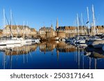 View of the marina of Saint Malo with reflections of boats, yachts and walls of the city in the sea. Brittany . France.