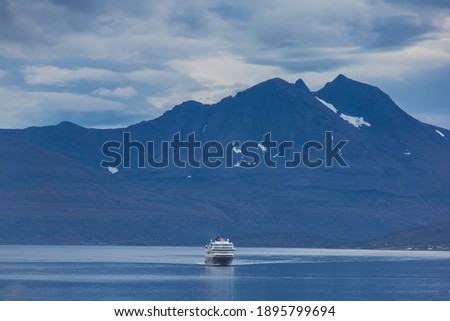 View of massive big ferry boat cruise line in Norway, with fjord harbor and bay in the background, Lofoten Islands, Nordland