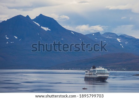 View of massive big ferry boat cruise line in Norway, with fjord harbor and bay in the background, Lofoten Islands, Nordland