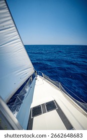 View from the mast down to the bow of a sailing yacht moving under full sails near Croatia. Freedom, adventure, yachting lifestyle and dynamic sea travel. High quality photo