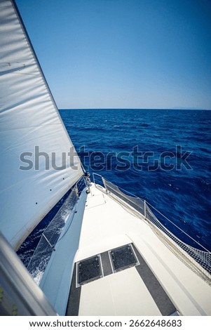 View from the mast down to the bow of a sailing yacht moving under full sails near Croatia. Freedom, adventure, yachting lifestyle and dynamic sea travel. High quality photo