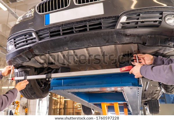 View\
of a mechanic repairing a lifted car. Repair area.\
