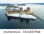 View of the medieval Olavinlinna fortress on Saimaa lake on a cloudy March day (aerial photography). Savonlinna, Finland