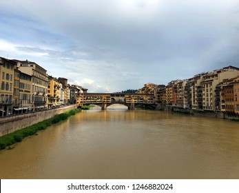 View of medieval stone bridge Ponte Vecchio and the Arno River from the Ponte Santa Trinita (Holy Trinity Bridge) in Florence, Italy. Florence is a popular tourist destination of Europe, rainy day.