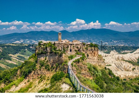 View of the medieval town of Civita di Bagnoregio, located on the top of a spur of tuff rock, in the middle of the valley of the badlands. Connected to the city by a small bridge, mule track. 