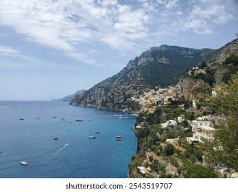 View of the Mediterranean Sea with boats in it and an Italian cliffside village. - Powered by Shutterstock