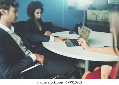 View Of Meeting Room In Office Settings With Group Of People Having Work Meeting: Caucasian Handsome Man Employer, Brazilian Young Woman Probationer And Caucasian Female Co-worker, Laptop On The Table