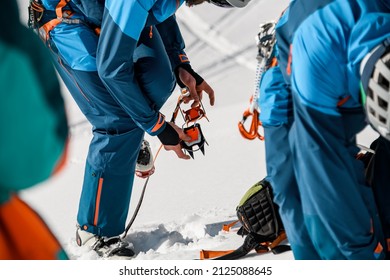 view of men hikers wears climbing crampons over mountaineering shoes for walking through glacier. Hiking equipment, mountaineering equipment, ice snow grips, anti slip crampons.