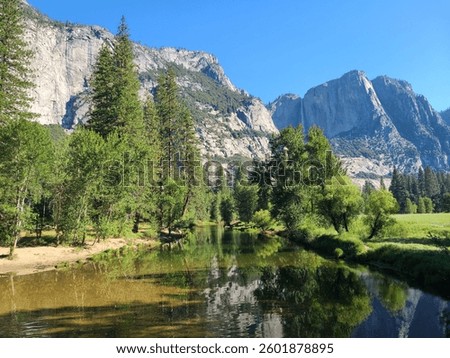 View of Merced River and surrounding cliffs and Yosemite Falls in Yosemite Valley, California