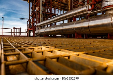 View From Metal, Steel Plate Floor Of Open Air Chemical Plant In Kenya. Industrial Building With Safety Features Evident At The End Of The Platform - Eye Bath, Railings And Fire Escape External Stairs