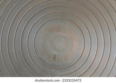 view of a metal texture that draws concentric circles, towards a worn center and worked with shades of color; potter's wheel plate