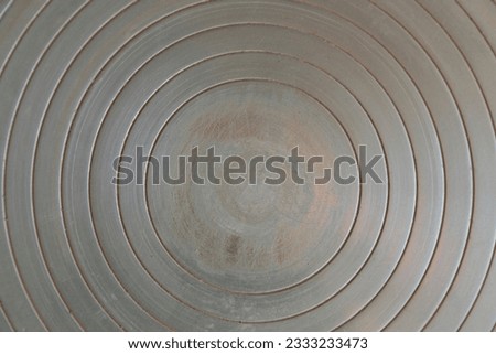 view of a metal texture that draws concentric circles, towards a worn center and worked with shades of color; potter's wheel plate