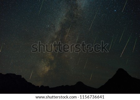 A view of a Meteor Shower and the Milky Way with mountains silhouette in the foreground.
