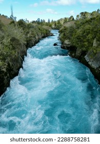 View of the mighty Huka Falls of the Waikato River with its beautiful blue-green aqua clear pool and foam near Taupo on the North Island of New Zealand.
