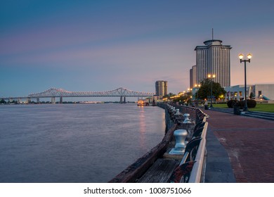  View Of The Mississippi River From The City Of New Orleans Riverfront, With The Great New Orleans Bridge On The Background In New Orleans, Louisiana, At Dusk.