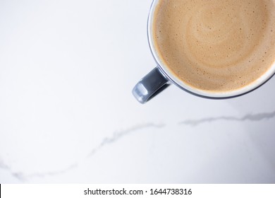 A View Of Mocha Latte Coffee Mug In A Top Down View On A Marble Counter In A Cafe Setting.