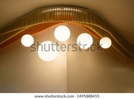 View of a modern beautiful ceiling light. Set of lamps interior with a brown wall in the modern house, The minimalist interior is decorated with circular light bulbs in warm tones 2024.