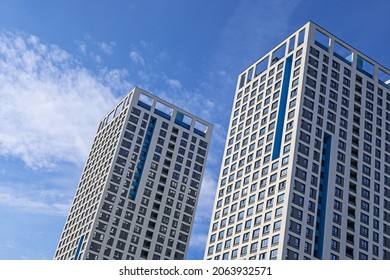 View of modern buildings against a blue sky with white clouds from an unusual angle - Powered by Shutterstock