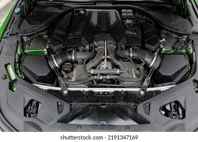 View to modern green car with opened bonnet. View under bonnet. Closeup.