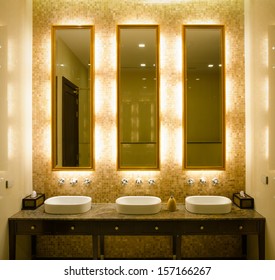 View Modern Style Interior Design Of A Bathroom. Install Bulb Behind A Mirror Glass Decorative Gold Picture Frame And Faucet And Wash Bowl On Table