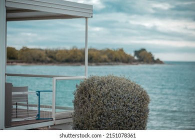 View From A Modern Summer Cottage Or House Or Glamping Towards The Sea. Bushy Decoration In Focus.