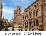 View of the monumental Plaza de Santo Domingo in Murcia, Spain, with several historic buildings, such as the Santo Domingo church with Trapería street in the background