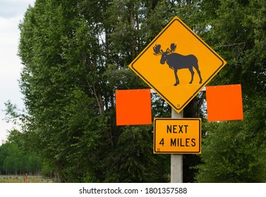 View Of A Moose Crossing Sign On The Road In Grand Teton National Park In Wyoming, United States