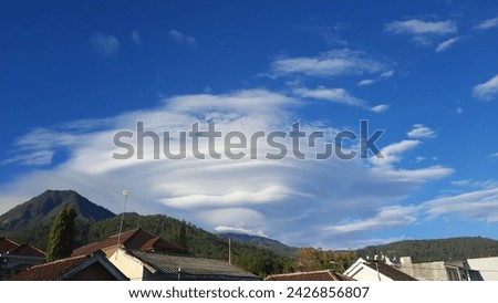 view of the morning sky with clumpy clouds and blue sky accompanied by houses
