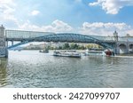 View of the Moscow river embakment, Pushkinsky bridge and cruise ships at sunset. Wide Moskva River, Pushkinsky bridge, Groky Park, Frunzenskaya embankment,