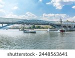 View of the Moscow river embakment, Pushkinsky bridge and cruise ships at sunset. Wide Moskva River, Pushkinsky bridge, Groky Park, Frunzenskaya embankment,