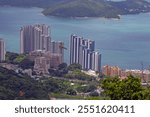 View from Mount Davis showing the passage to Hong Kong harbor, framed by lush green hills and sea during daytime