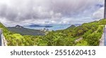 View from Mount Davis showing the passage to Hong Kong harbor, framed by lush green hills and sea during daytime