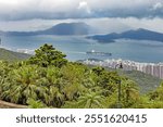 View from Mount Davis showing the passage to Hong Kong harbor, framed by lush green hills and sea during daytime