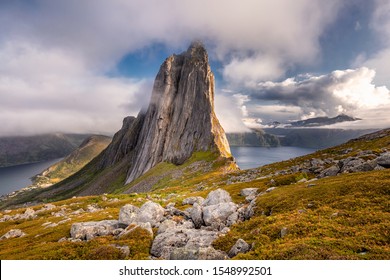 View from Mount Hesten on Iconic Mountain Segla in light of epic sunsetcovered in fog and mountain range in background, Fjordgard, Senja, Norway sunset Segla mountain.