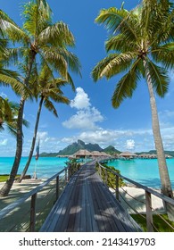 View of the Mount Otemanu through turquoise lagoon, palm trees and overwater bungalows on Bora Bora island, Tahiti, French Polynesia, South Pacific