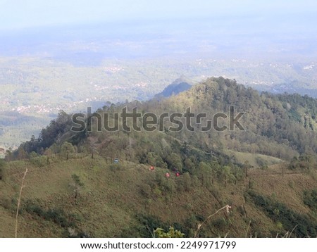 the view of Mount Wilis in the morning with a rural background and a slightly cloudy clear sky