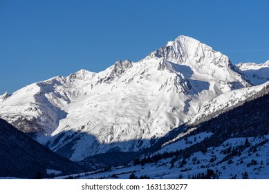 View of a mountain lit by the morning sun. View of a perfect blue sky.