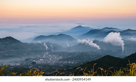 a view of a mountain range covered in fog and mist from a bird's eye view of the mountains in the distance is a hazy sky.  generative ai