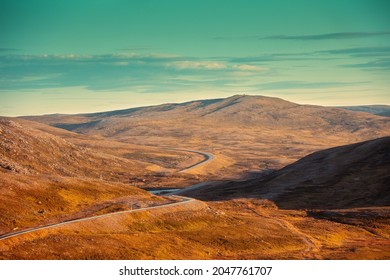 View of mountain winding road in valley. Beautiful harsh north minimalist landscape. Nature of Norway. Polar circle. The way to Nordkapp (North Cape). Norway, Europe