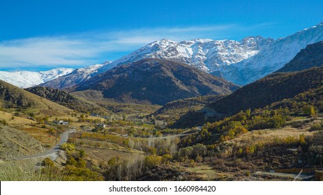 a view of mountains covered with snow in the fall session in  the north of Iraq Kurdistan Region with green landscape and trees in the foreground