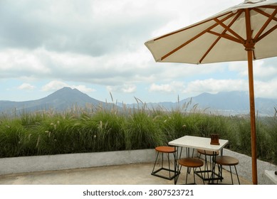 View of mountains and grass from a cafe table with an umbrella