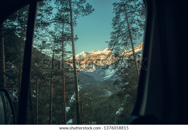 view of the mountains and trees from the window\
of the car during the\
journey