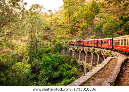 View from moving train on arch bridge over mountain slopes, beautiful view, one side mountain, one side valley. Toy train from Shimla to Kalka in Himachal Pradesh, India