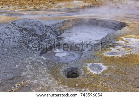 View to a mudpot, or mud pool. It is a sort of acidic hot spring, or fumarole, with limited water. It usually takes the form of a pool of bubbling mud. Iceland.