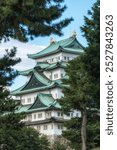 View of Nagoya Castle a famous iconic Japanese palace in between the pine trees. Taken in Nagoya, Japan