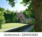 View near a tree to the front of main portal with stonebridge over moat at Marienberg fortress in Würzburg, Franconia