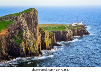 View of Neist Point lighthouse and rocky ocean coastline, highlands of Scotland
