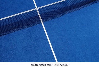 View of the net and the centre line of a blue paddle tennis court. Racket sports - Powered by Shutterstock